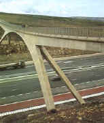 narrow concrete footbridge over a motorway